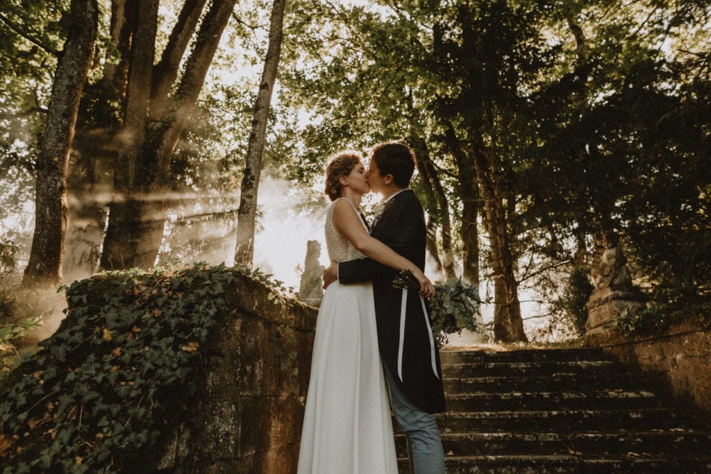 mariés qui s'embrassent sur les marches du jardin du chateau de boucq