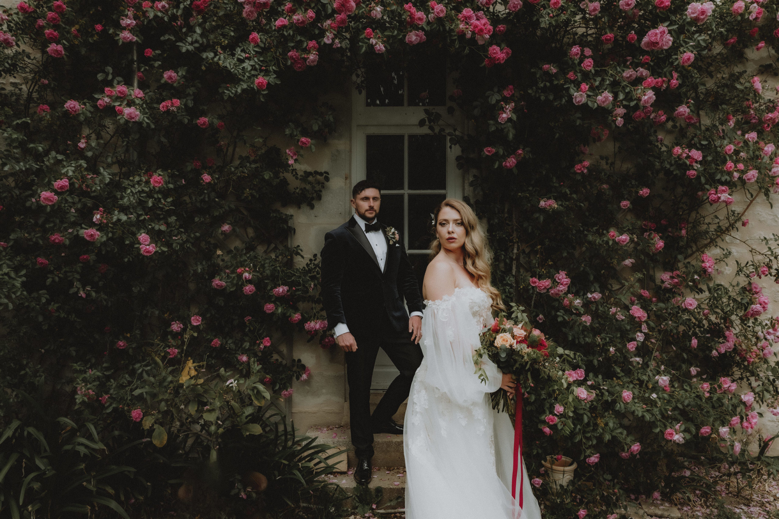 portrait de mariés devant des roses et rosiers